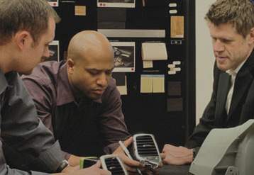 Three FCA employees analyze automotive components