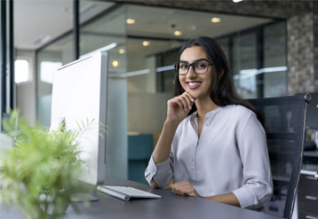 A young woman seated at an office desk.