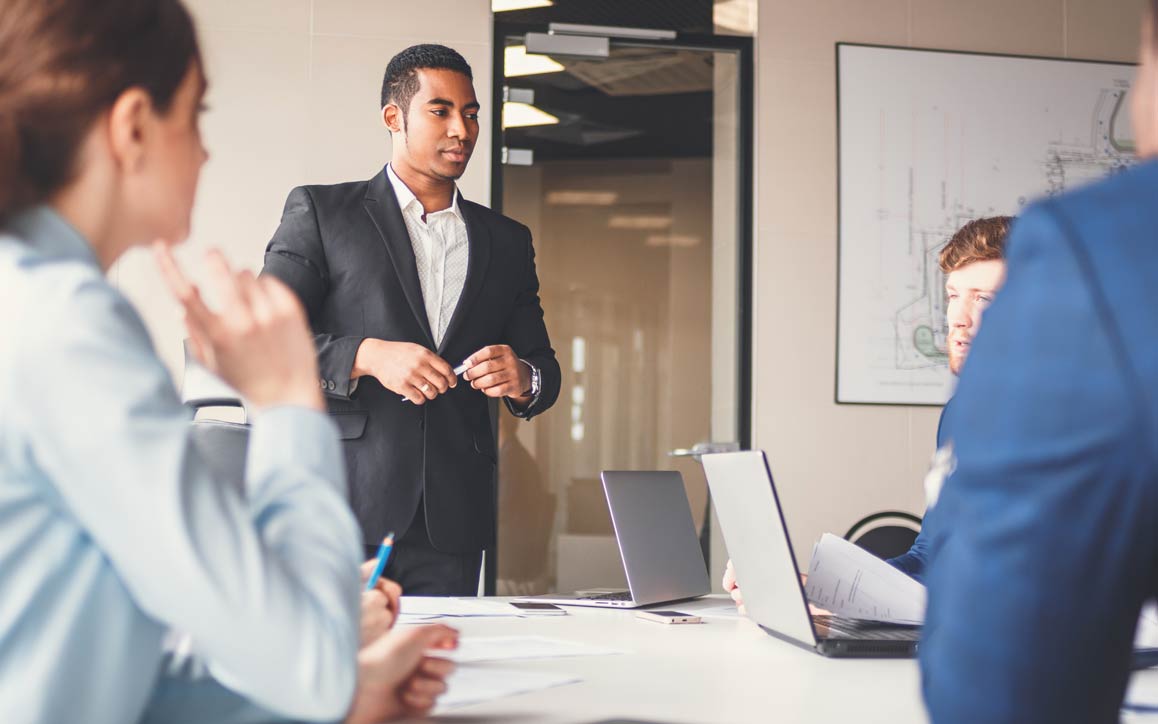 Man presenting ideas to coworkers in meeting room