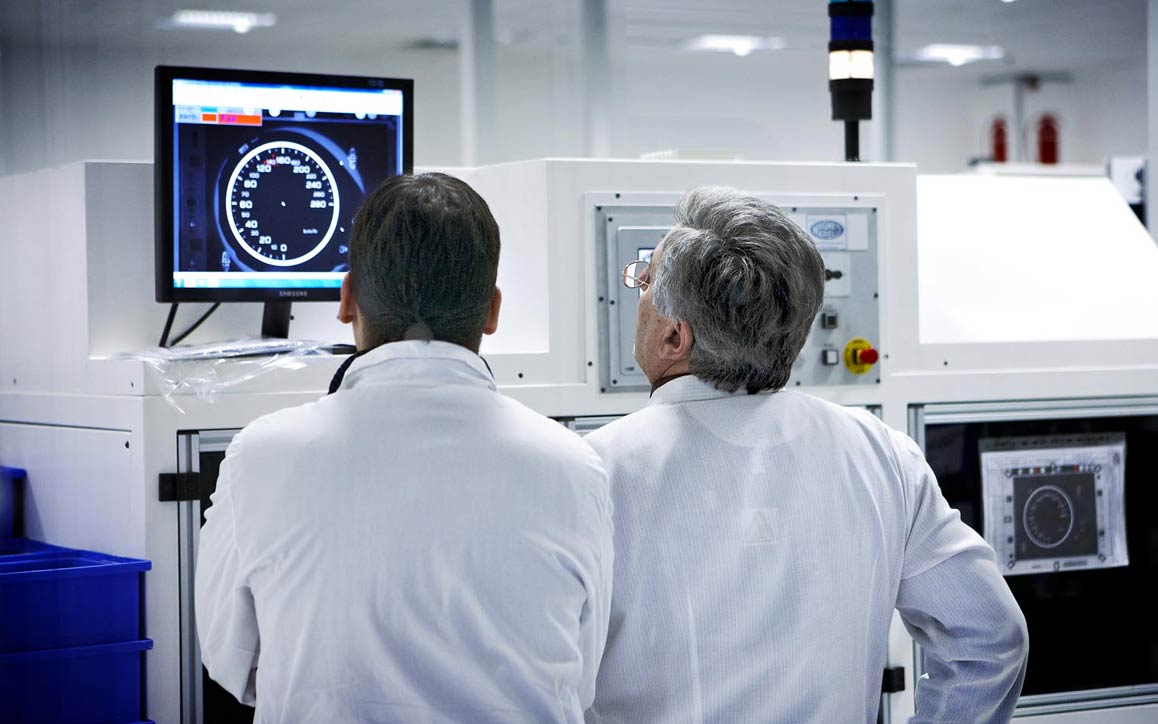 Employees analyzing engine performance on computer screen