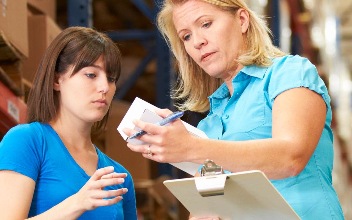 aot_SPW_srvs_parts_quality Two female employees verify parts in warehouse