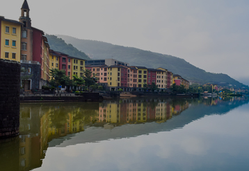 Colorful row of buildings reflecting along still river water