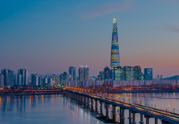 Seoul cityscape reflects across a body of water at dusk