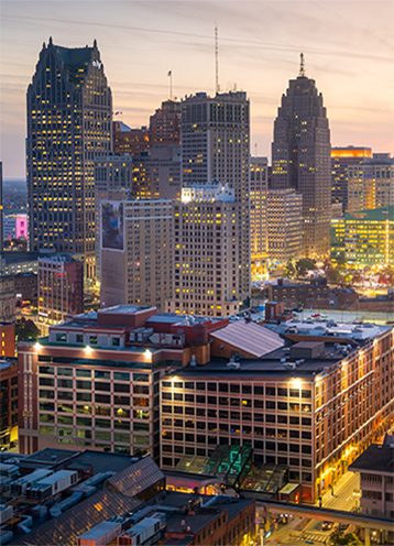 g4 Downtown Detroit cityscape at dusk with lights shining out from buildings