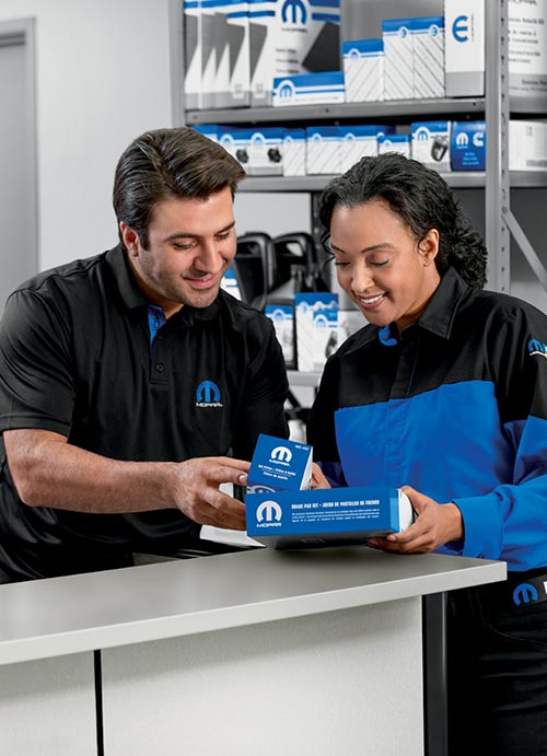 两名员工查看 Mopar® 售后零件。