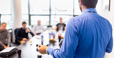 Man giving a presentation to coworker sitting around a table