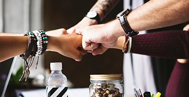 Group of employees fist bumping