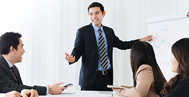 동료와의 회의에서 프리젠테이션 보드를 가리키는 남성