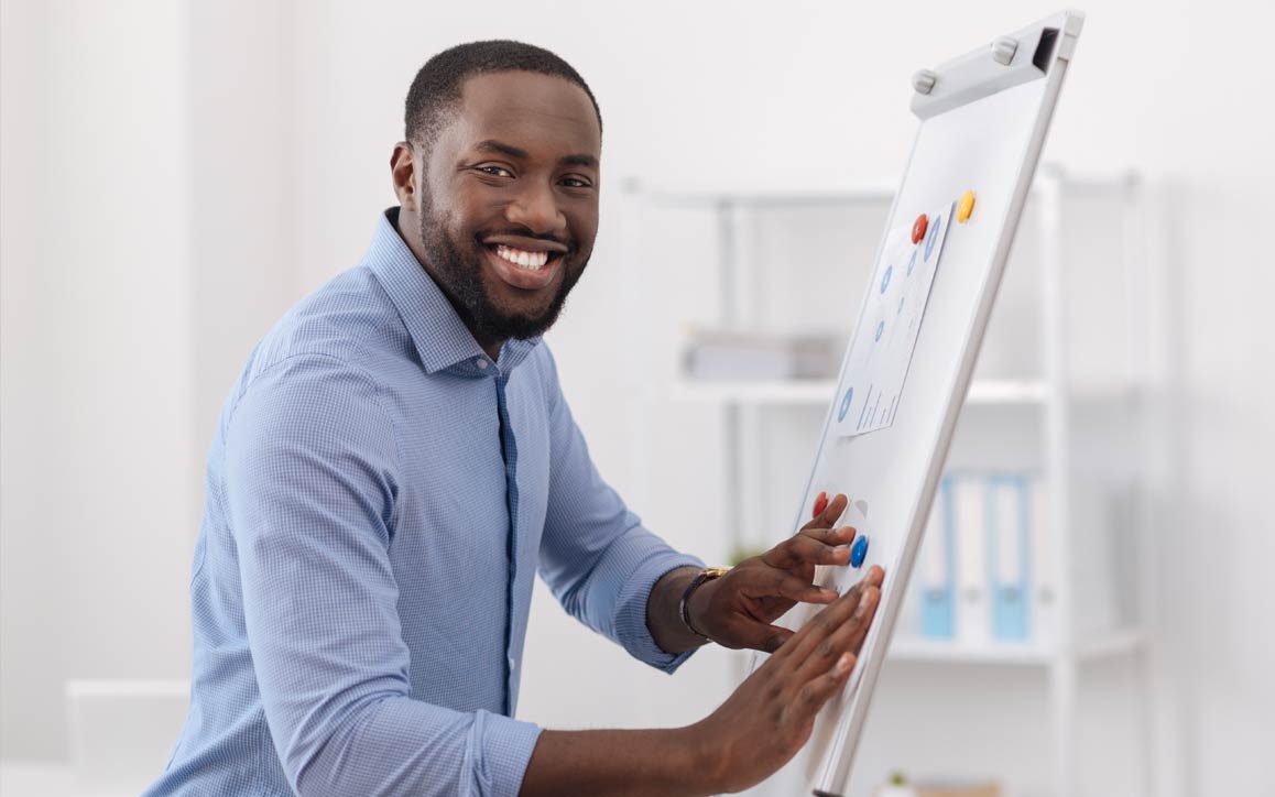 Homem em ambiente de escritório, trabalhando no quadro branco