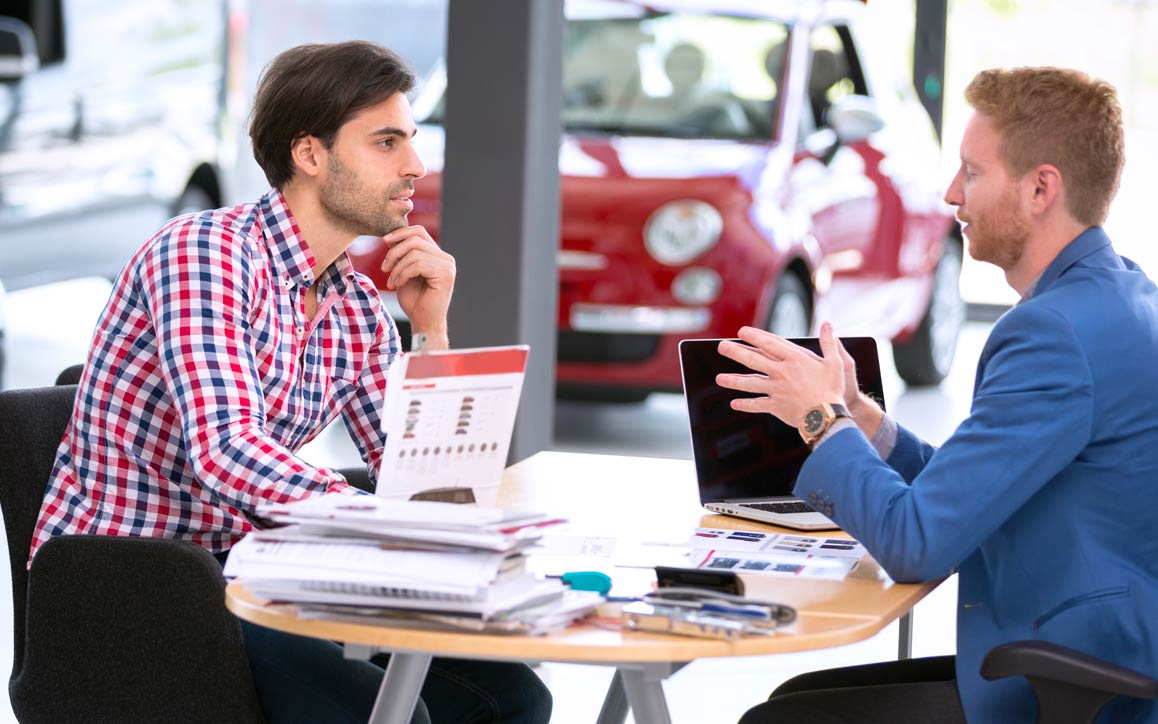 Funcionário e cliente em um showroom de carros