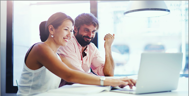 EMEA-whychoose-blended-ko 책상에 앉아 함께 노트북을 보는 두 동료