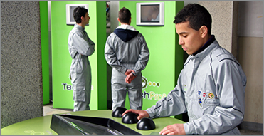 EMEA-whychoose-community-ko 두 직원이 초록색 벽의 디스플레이를 보는 한편, 테이블의 모니터를 보는 다른 직원