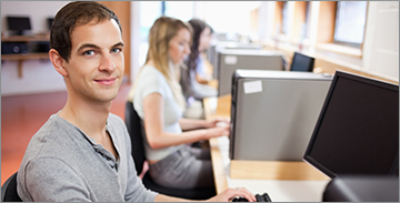 앞에서 컴퓨터로 작업하는 남학생